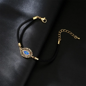 Adjustable evil eye charm bracelet with gold plating and blue crystals on black cord
