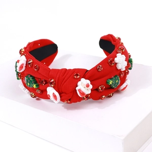 Detailed view of red knotted Christmas headband with Santa, snowflake and rhinestone decor