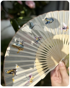 Close-up of handmade Suzhou silk embroidery folding fan with colorful butterfly patterns