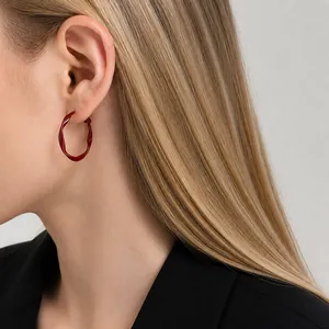 Close-up of a 3cm red twisted hoop earring worn by a model in Chinese style