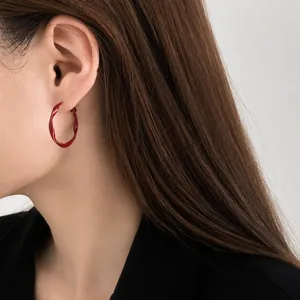 Close-up of a 3cm red twisted hoop earring worn by a model in Chinese style