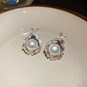 Detailed close-up of water drop pearl earrings with baguette-cut zircon in gold frame