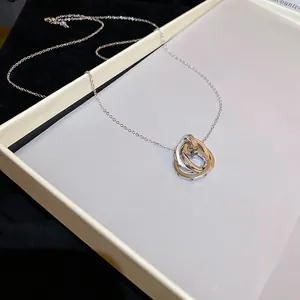 Minimalist interlocking triple ring pendant necklace with thin silver chain on tray