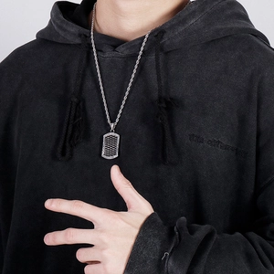 Detail of silver vintage punk dog tag pendant with diamond accent on male model