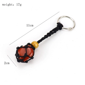 Detail view of red-brown crystal stone in black woven net keychain with size markings
