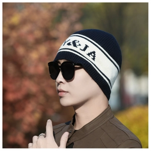 Détail du bonnet en maille rayé marine et beige avec broderie de lettres noires