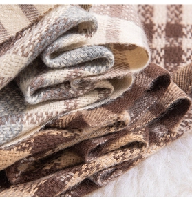 Close-up of thick British plaid scarf with soft fabric texture and fringe details
