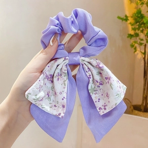Detail of purple floral bow scrunchie showing soft chiffon texture and sweet pattern
