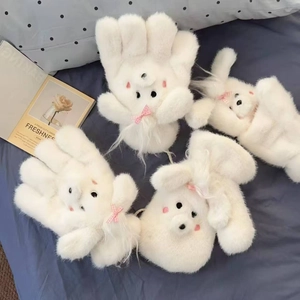 Cute white plush dog-style winter gloves with pink bows on a blue polka dot background