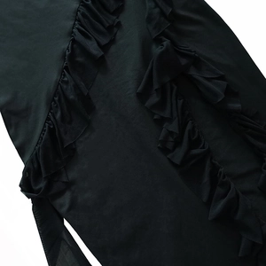 Detail view of layered black ruffles on a side slit dress with premium textured fabric