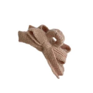 Beige knit bow hair claw clip with plush texture for women shown on white background