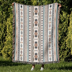 Detail of bohemian outdoor camping blanket featuring ethnic patterns and fringe edges