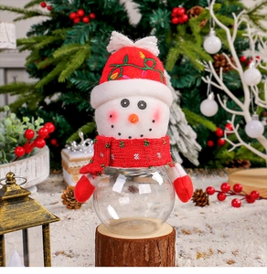 Detailed view of a plush snowman Christmas candy jar on a rustic wooden base with festive decor