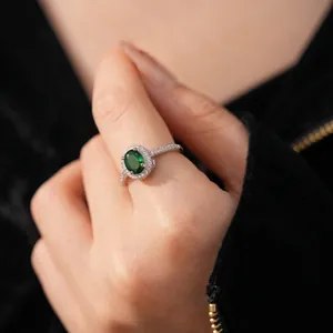 Elegant silver open ring with oval green gemstone and zircon pavé on a model hand