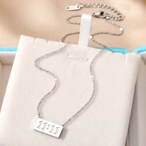 Macro view of silver stainless steel 11:11 angel number necklace on a jewelry box liner