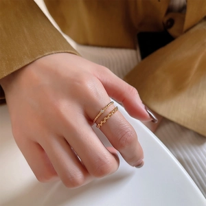Detail of 925 sterling silver gold beaded rings set on finger with zircon accent