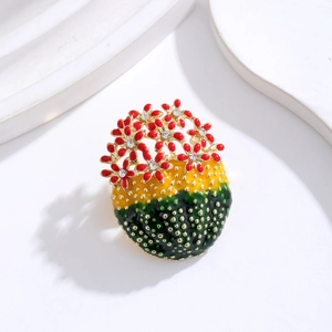 Elegant enamel cactus brooch with red flowers and crystals on a minimalist white background