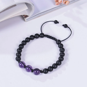 Detail view of adjustable braided bracelet with matte black beads and purple amethyst stones