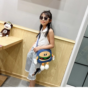 Detailed view of kids cartoon burger shoulder bag with plush 3D arms and legs on blue fabric