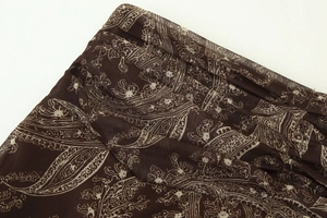 Vue macro détaillée du motif paisley marron foncé sur tissu en mousseline plissée légère