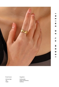 Close-up of a gold V-shaped titanium ring with brushed texture on a model finger