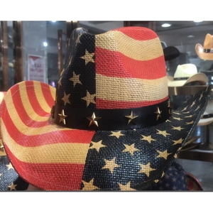 Detail of USA flag straw cowboy hat with leather band and gold star studs decor