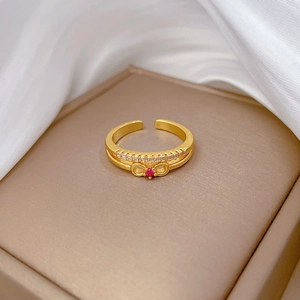 Macro detail of gold bow ring with pink gemstone and micro-pave setting on jewelry box