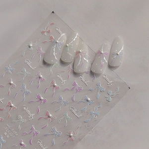 Detail view of 3D bowknot nail art stickers with embossed pearls and polka dots