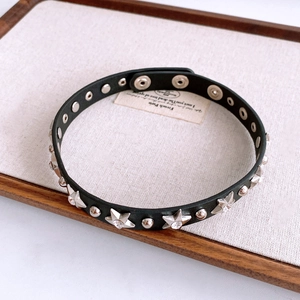 Detail of punk black leather choker with silver star rivets and round metallic studs