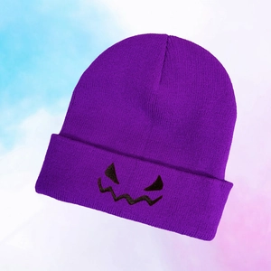 Close-up of purple knitted beanie featuring black embroidered monster face details