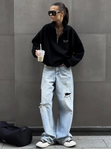 Streetwear set featuring a black half-zip sweatshirt and distressed wide-leg jeans