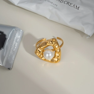 Bague nœud minimaliste dorée avec grande perle blanche sur anneau en métal texturé