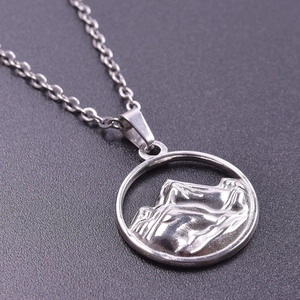 Macro view of silver stainless steel mountain pendant necklace with fine chain detail