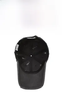 Detail of distressed black cotton baseball cap showing internal labels and frayed texture