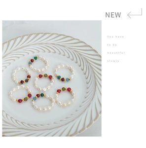 Detailed set of 7 handmade pearl bead rings in white ceramic dish with color accents