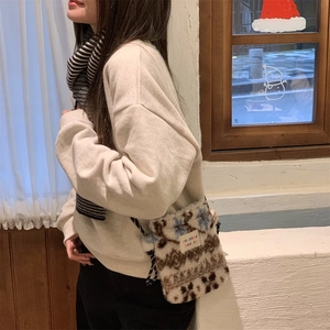 Detail of plush leopard print crossbody bag with white brand label and braided strap