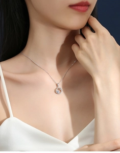 Close-up of a silver Moissanite pendant necklace with a brilliant round halo design