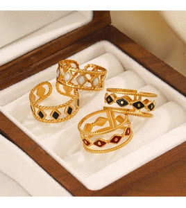 Detailed macro view of vintage gold-plated diamond enamel rings in a wooden jewelry box