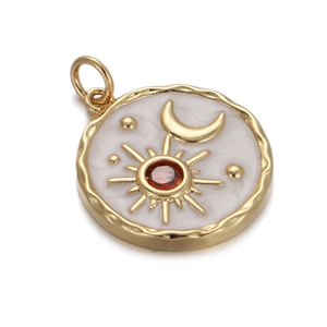 Detailed view of a gold plated celestial charm with sun moon motifs and a red gemstone
