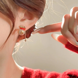 Boucles d'oreilles sac de fortune en or avec micro-diamants et glands sur un mannequin