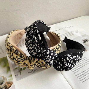 Close-up of yellow and black leopard print knot headbands resting on a book page