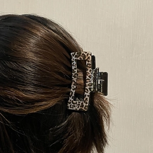 Leopard print rectangular hair claw clip shown styling long brown hair from a back view
