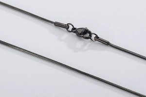 Macro detail of gunmetal black snake chain necklace with lobster clasp and metal caps