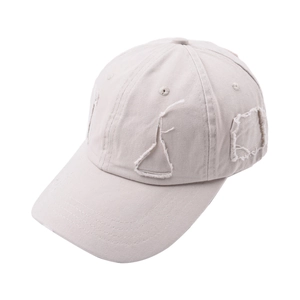 Detailed close-up of distressed vintage beige baseball cap showing worn fabric patches