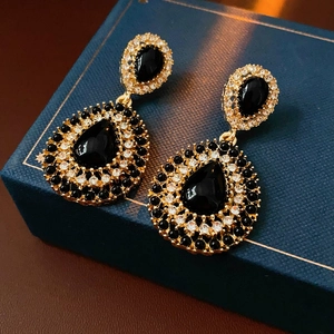 Gros plan de boucles d'oreilles vintage en goutte avec pierres noires et cristaux brillants