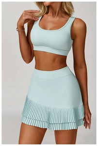 Detail of light mint green yoga set featuring a cropped top and pleated high-waisted skirt