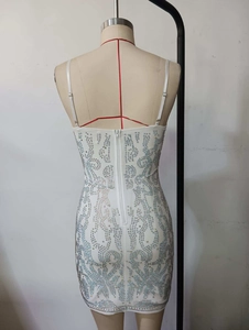 Close-up of white mini dress with silver rhinestones and back zipper detail