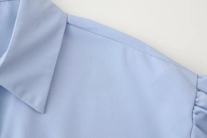 Detail of light blue lapel shirt showing shoulder stitching and fabric texture