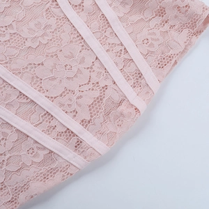 Detail of pink floral lace fabric with parallel ribbon trim on a long sleeve top