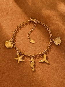 Vue détaillée du bracelet marin plaqué or 18K avec pendentifs hippocampe et étoile de mer